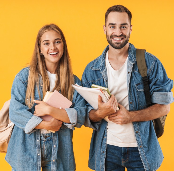 N'attendez plus pour demander l'ACS ! Deux étudiants avec le sourire portant leurs livres - La SMENO vous dit tout sur les critères pour obtenir de l'aide !